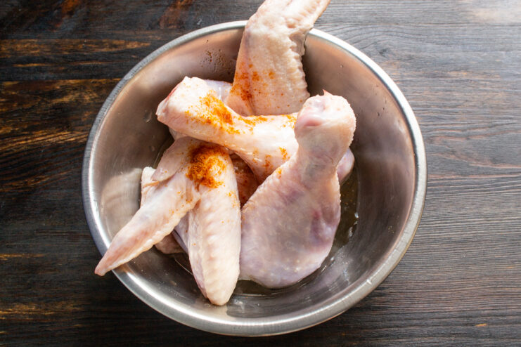 Raw chicken skin marinating in white wine and spices.