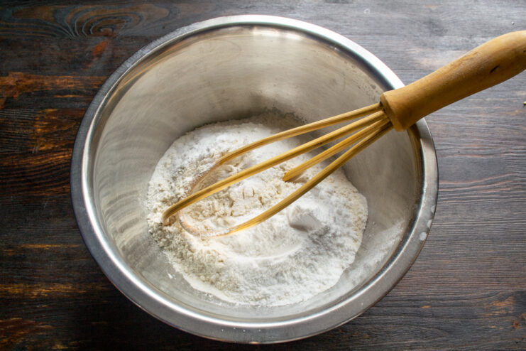 Sifting flour and adding dry ingredients into a mixing bowl