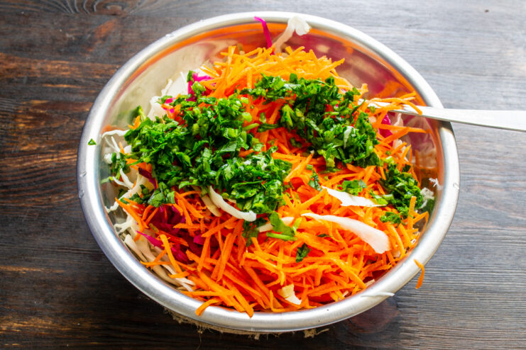 Finely chopped fresh parsley and cilantro added to a salad bowl.