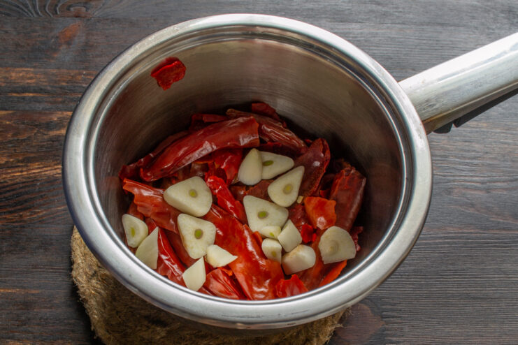 Adding fresh garlic Sliced fresh garlic added to the softened chili peppers