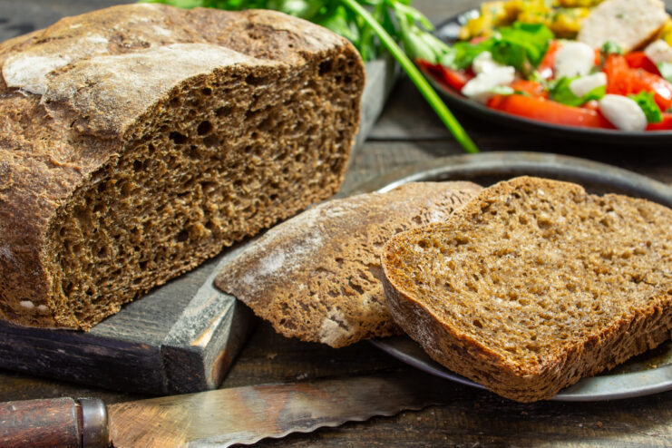 Sliced sourdough rye bread on a wooden cutting board