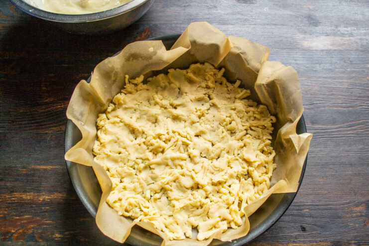 Coarsely grated frozen dough distributed evenly in a baking pan