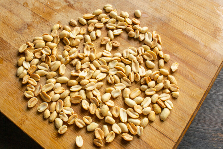 Roasting peanuts for the truffles Roasted blanched peanuts cooling on a wooden cutting board