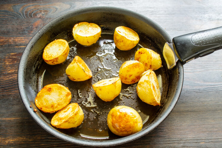 Golden crispy new potatoes frying in a hot skillet