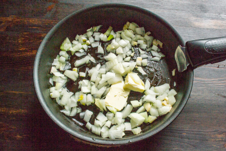 Sautéing the Onions Chopped onions and garlic cooking in a skillet with melted butter