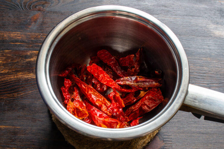 Rinsing the chili peppers Rinsed and cleaned dried chili peppers in a metal saucepan