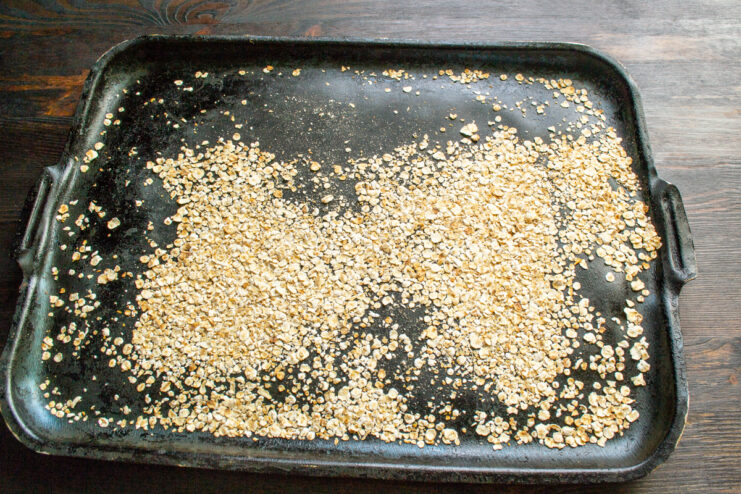 Toasting rolled oats for the coating Rolled oats spread on a baking sheet for toasting