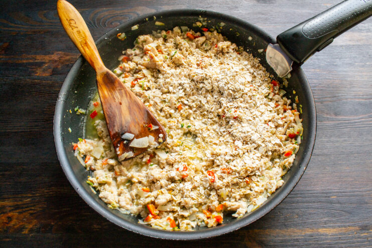 Stirring In Oats Quick-cooking oats stirred into the ground meat filling in a pan