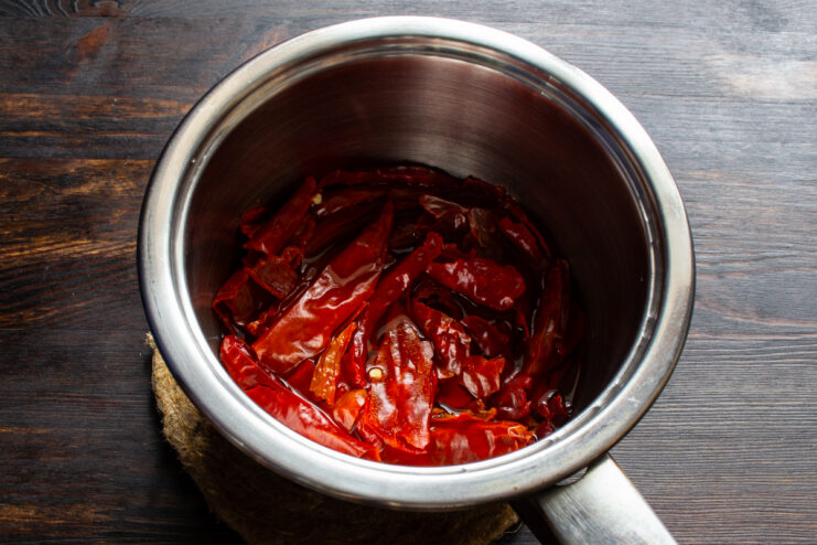 Soaking chilies in boiling water Dried chili peppers soaking in hot water in a saucepan