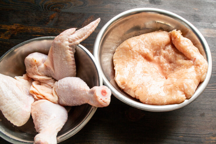 Prep work with separated chicken skin and meat for grinding in bowls.