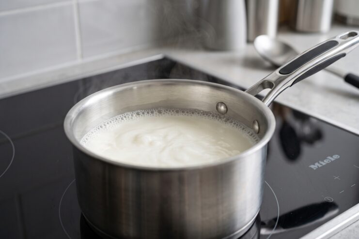 Heating Milk for Cocoa Hot milk shimmering in a saucepan with small bubbles along the edges
