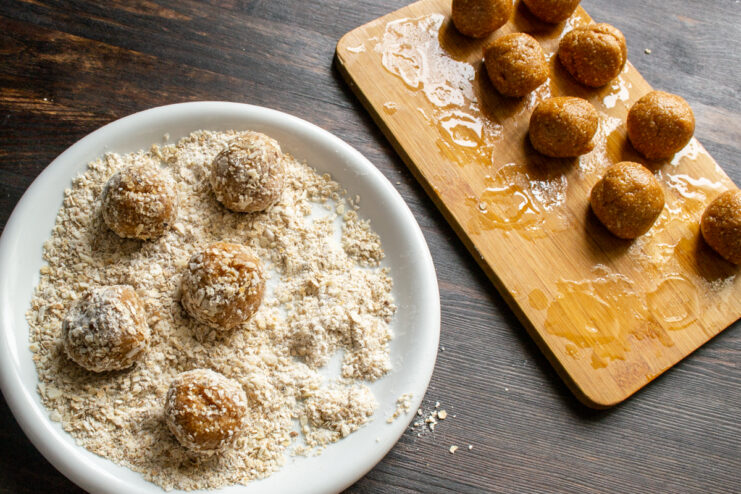 Rolling truffles in the oat coating Rolling peanut truffles in a finely ground oat and almond crumb coating