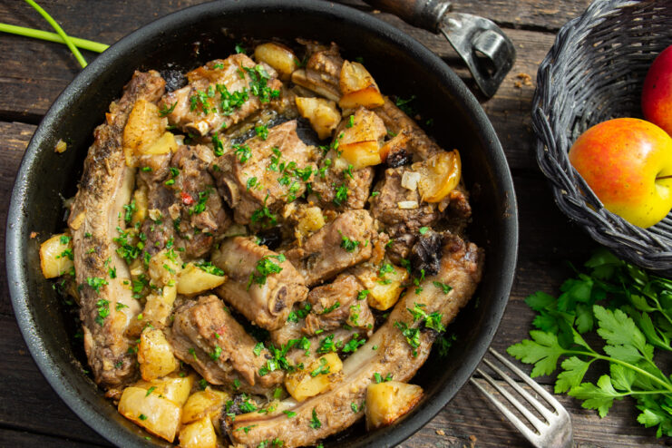 Oven braised pork ribs with apples and vinegar in a baking dish