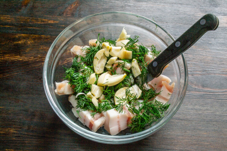 Diced pork fat, dill, and minced garlic combined in a bowl