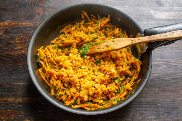 Lentil Filling Mixing cooked lentils with vegetables in a pan