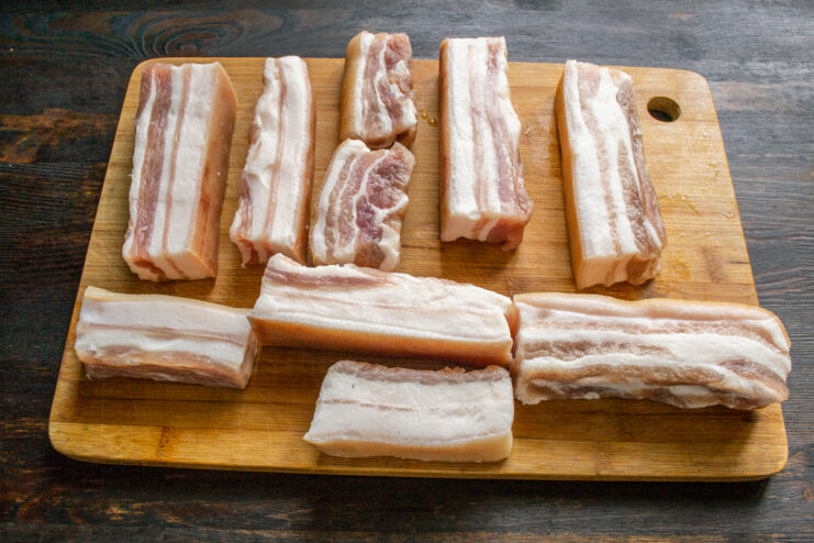 Cured pork fat resting on a wooden cutting board