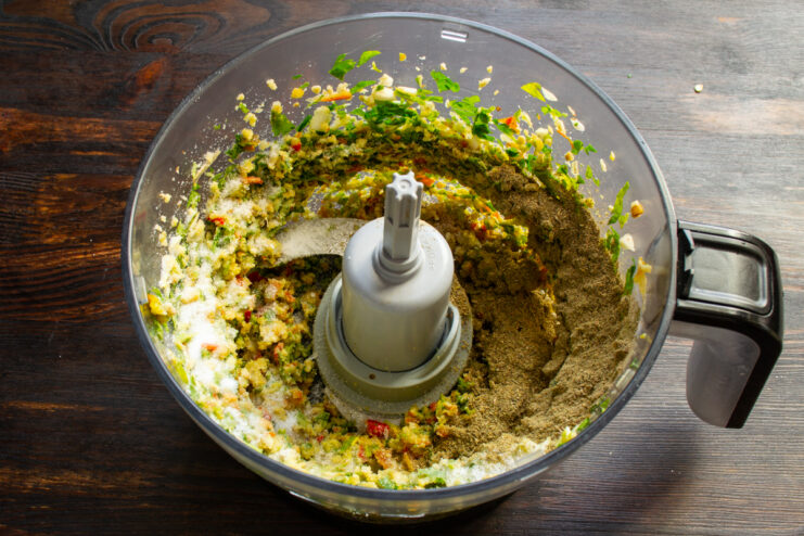 Adding salt and khmeli-suneli to the mixture Khmeli-suneli spice blend and salt sprinkled over the blended vegetable mixture.