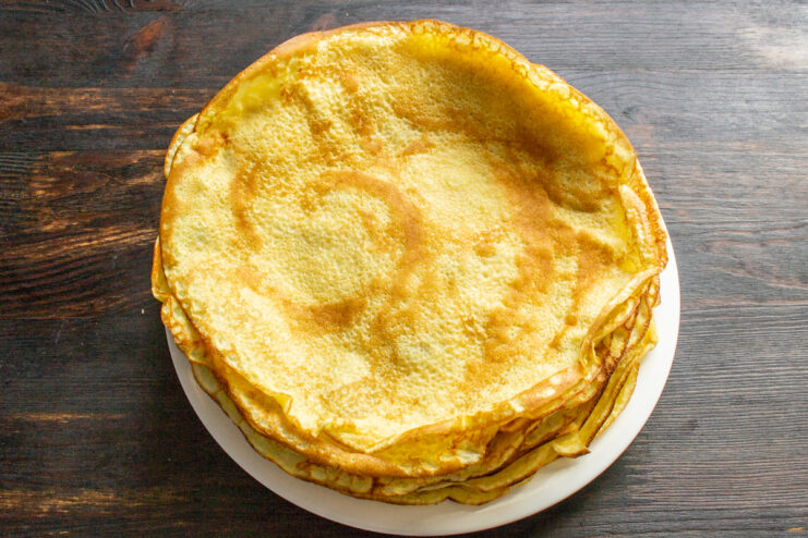 Stacking The Crepes Stack of thin golden crepes resting on a plate