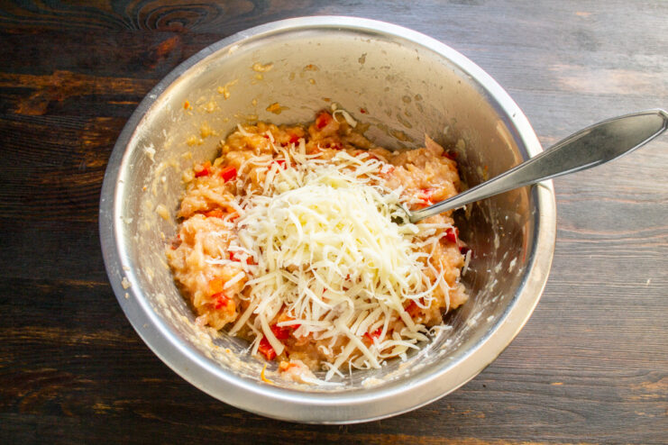 Folding in the mozzarella cheese Grated mozzarella cheese placed on top of the ground meat in a bowl