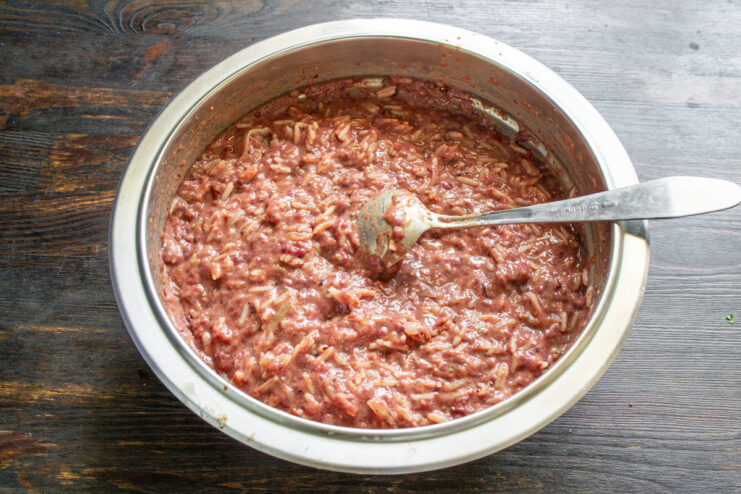 Resting The Sausage Filling Thoroughly mixed sausage filling resting in a metal bowl.
