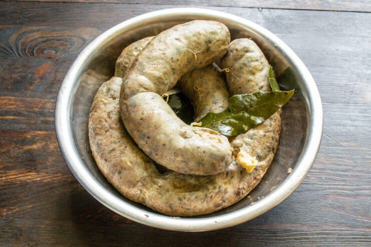 Poached Liver Sausage Boiled liver sausage in a bowl with a bay leaf after cooling.