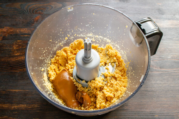 Incorporating the binding ingredients Caramelized sweetened condensed milk added to the peanut mixture