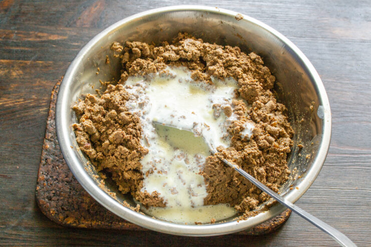 Mixing reconstituted milk into pâté Pouring liquid milk into the ground liver mixture