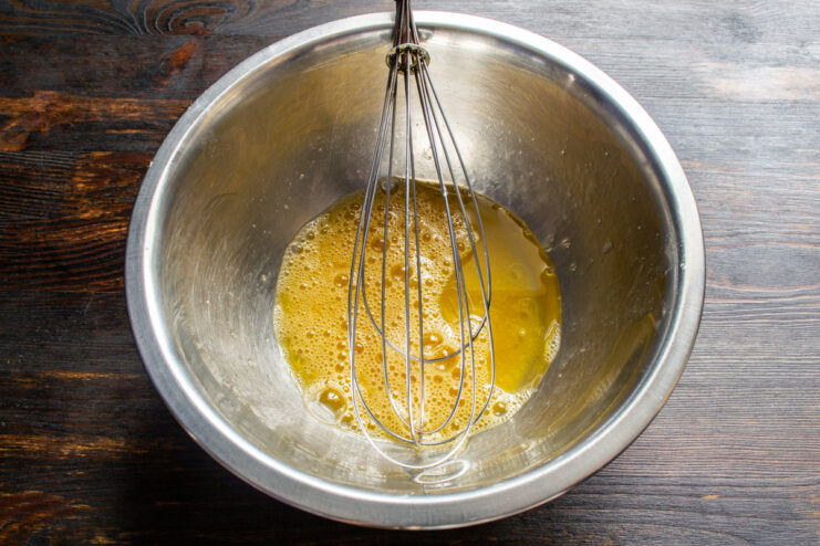 Mixing Eggs And Oil Whisking eggs and vegetable oil together in a metal bowl