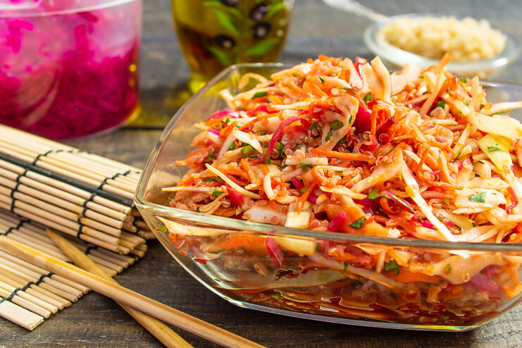 Vibrant cabbage and quinoa salad served in a clear glass bowl.