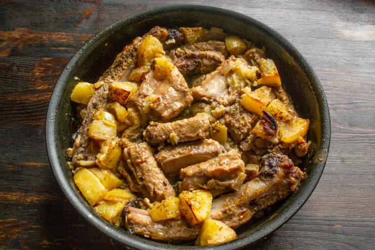 Finished Dish Out of the Oven Oven-baked pork ribs with soft apples in a roasting pan